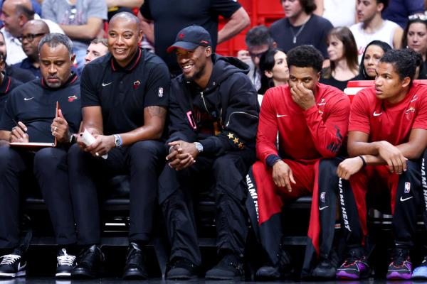 MIAMI, FLORIDA - OCTOBER 10: Jimmy Butler #22 of the Miami Heat (C) looks on from the bench during the second quarter of a preseason game against the Charlotte Hornets at Kaseya Center on October 10, 2023 in Miami, Florida. NOTE TO USER: User expressly acknowledges and agrees that, by downloading and or using this photograph, User is consenting to the terms and conditions of the Getty Images License Agreement. (Photo by Megan Briggs/Getty Images)